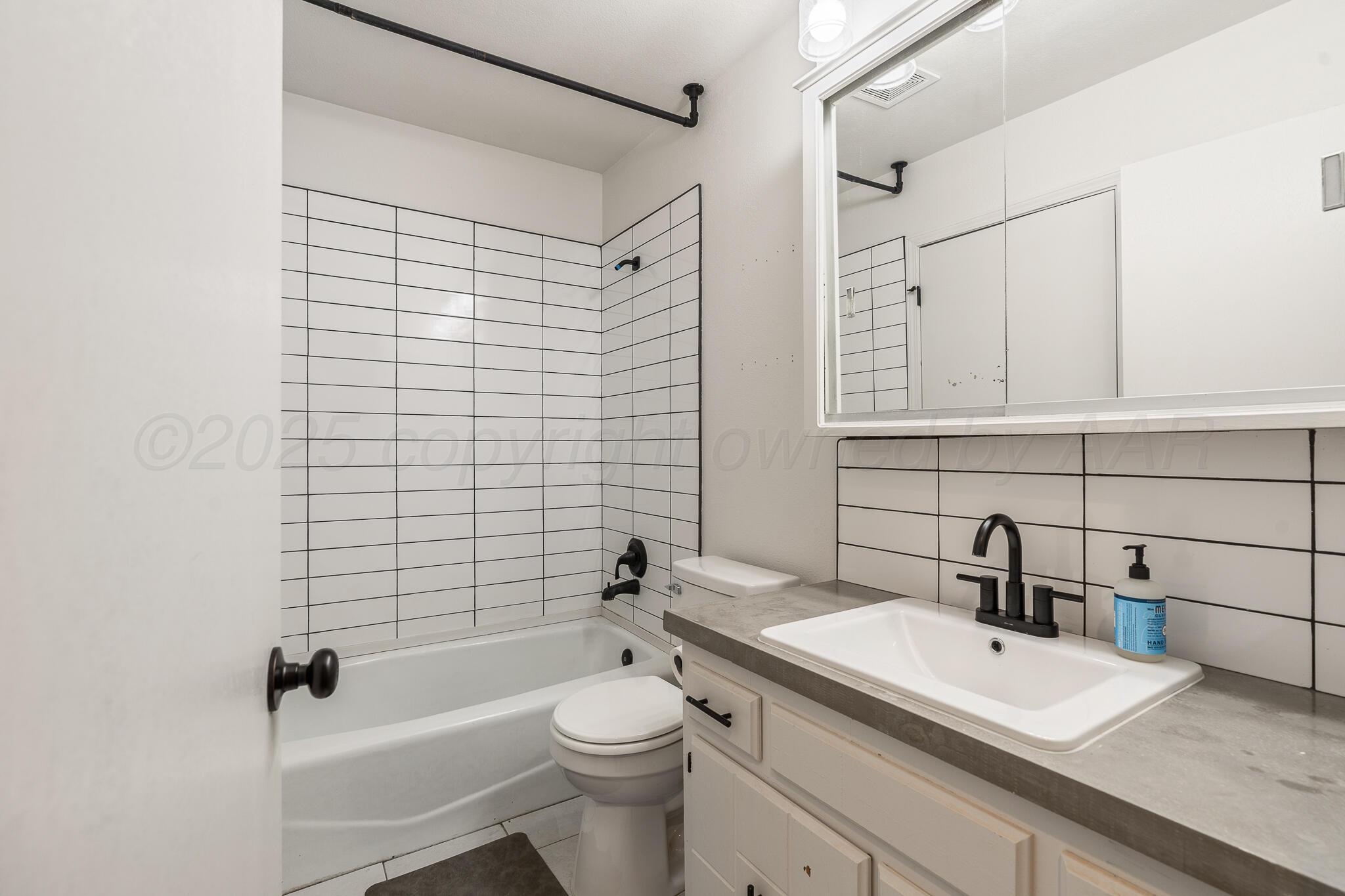 6212 Rutgers Street Amarillo, TX 79109 - Photo 19 of 26 a bathroom with a sink a toilet and shower