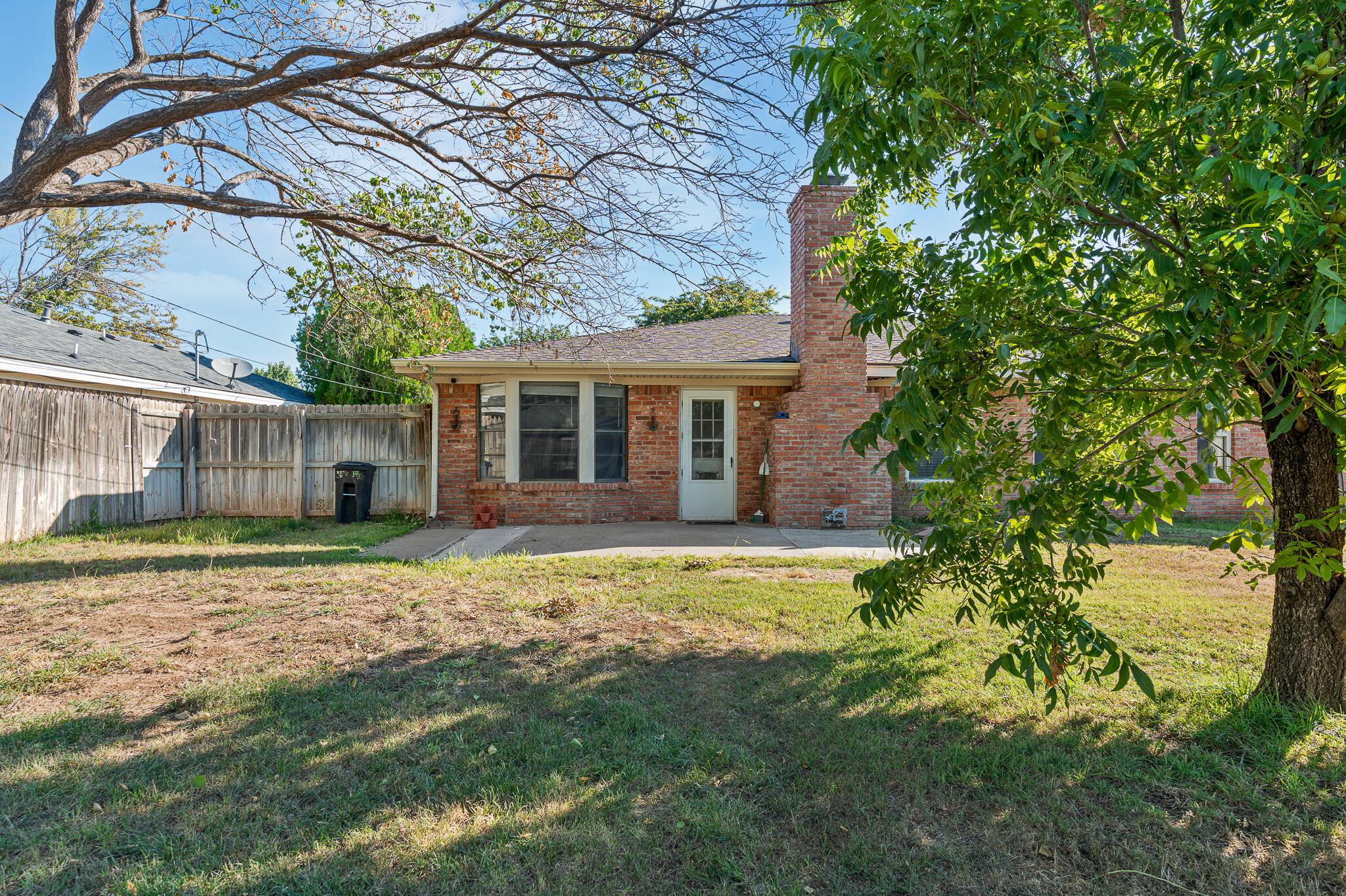 6212 Rutgers Street Amarillo, TX 79109 - Photo 25 of 26 a backyard of a house with table and chairs under an umbrella