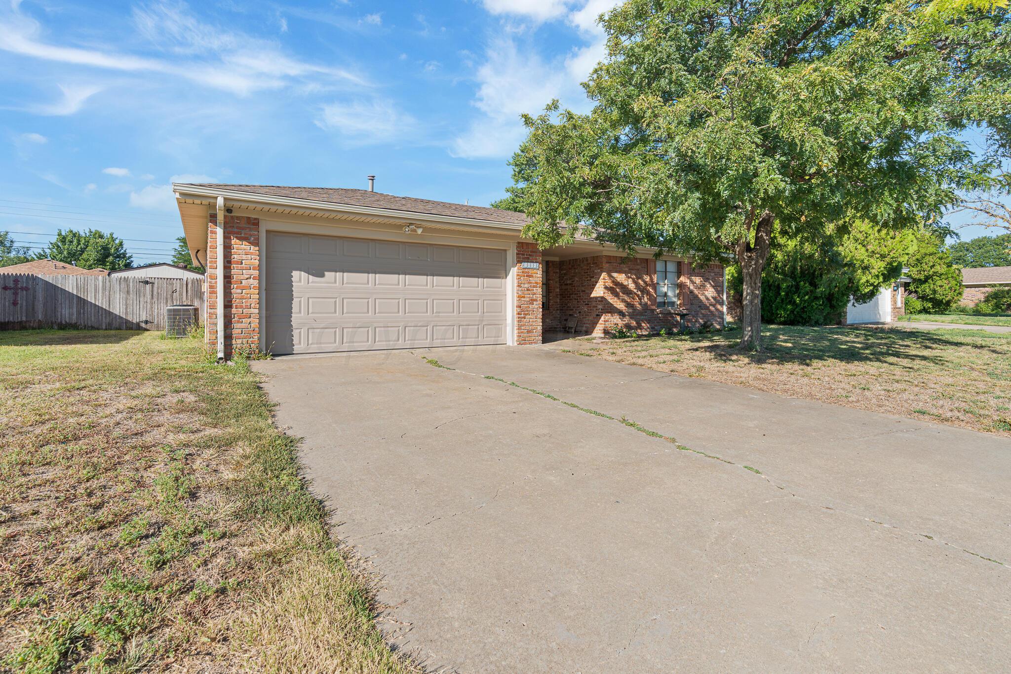 6212 Rutgers Street Amarillo, TX 79109 - Photo 3 of 26 a view of a house with backyard and trees