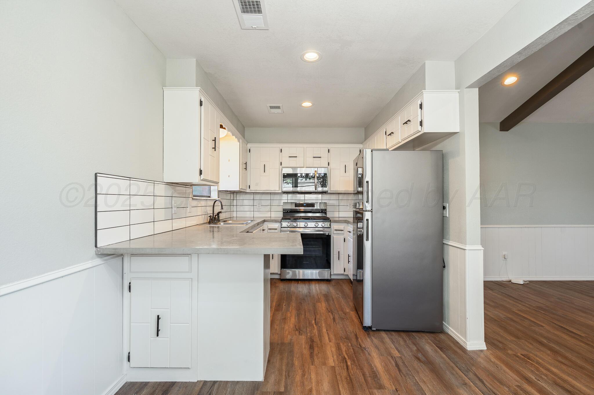 6212 Rutgers Street Amarillo, TX 79109 - Photo 10 of 26 a kitchen with stainless steel appliances a refrigerator sink and cabinets