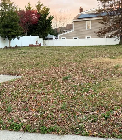 a front view of a house with a yard covered with snow