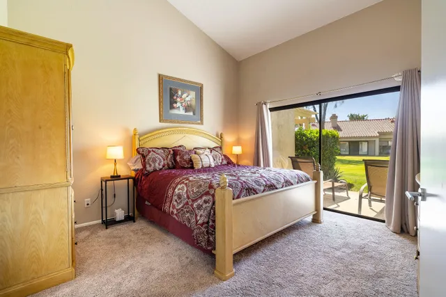 a bedroom with a bed and a dresser next to a window
