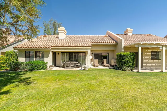 a front view of a house with swimming pool having outdoor seating