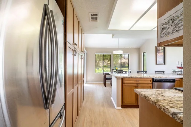 a kitchen with stainless steel appliances granite countertop a refrigerator a stove and a sink