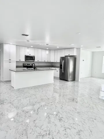 a kitchen with stainless steel appliances a refrigerator sink and microwave