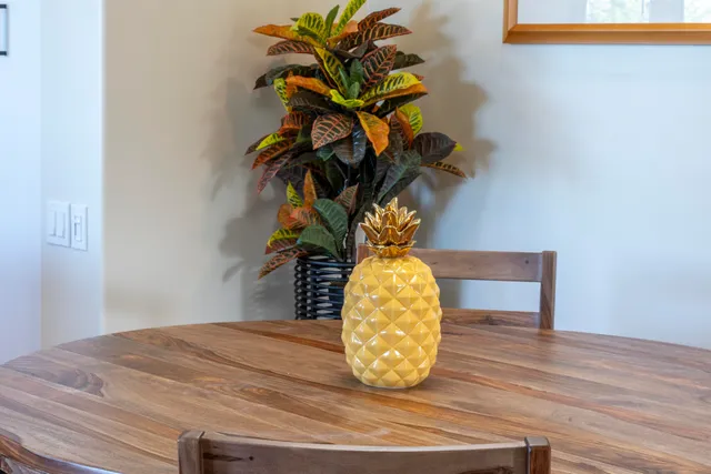 a kitchen with stainless steel appliances granite countertop a refrigerator a sink dishwasher a stove a dining table and chairs with wooden floor