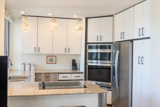 a kitchen with stainless steel appliances granite countertop a refrigerator and a sink