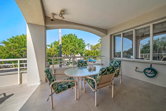 a roof deck with table and chairs with potted plants