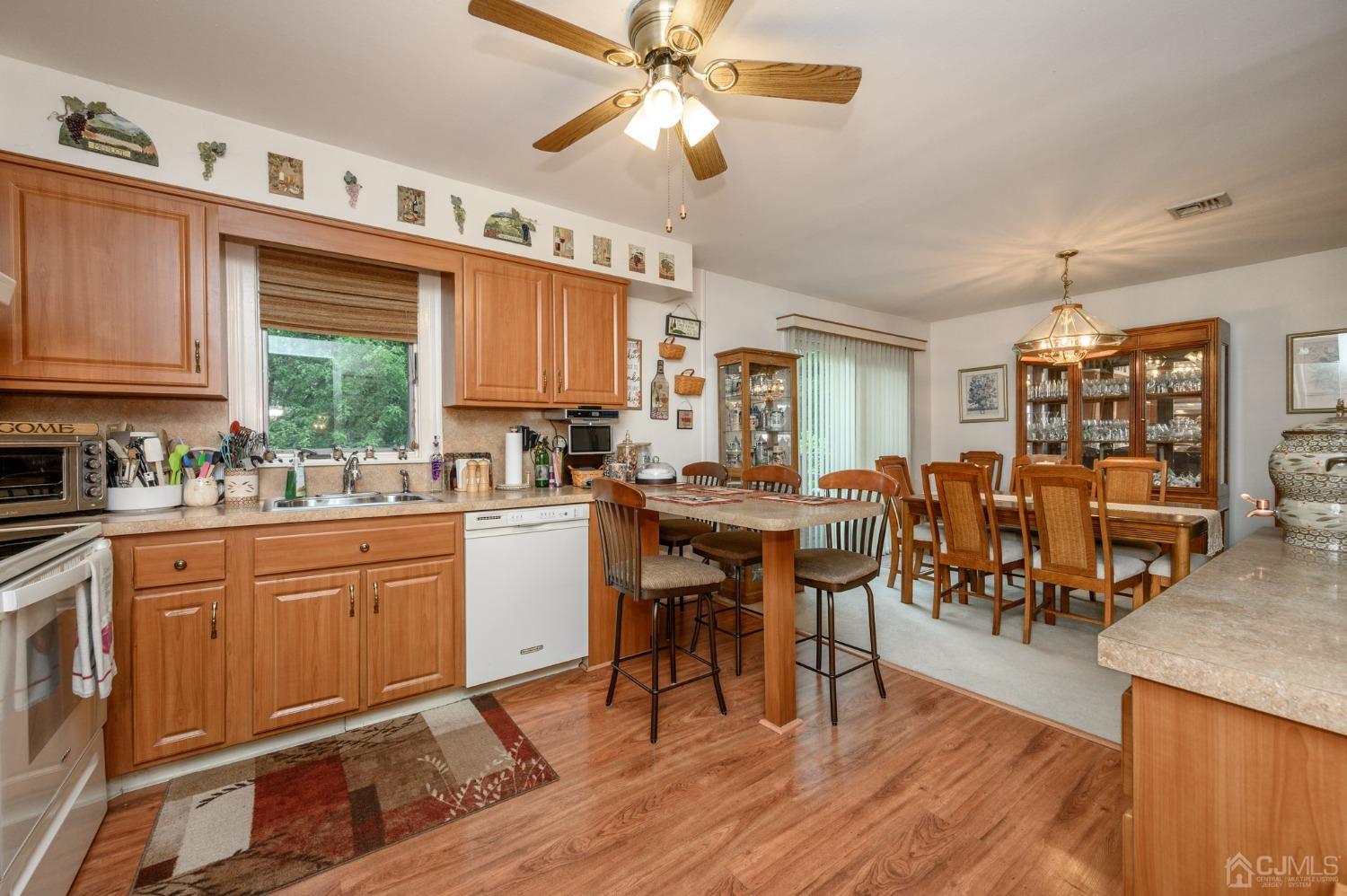 25 Sunset Drive Andover, NJ 07821 - Photo 11 of 43 a kitchen with cabinets wooden floor dining table and stainless steel appliances