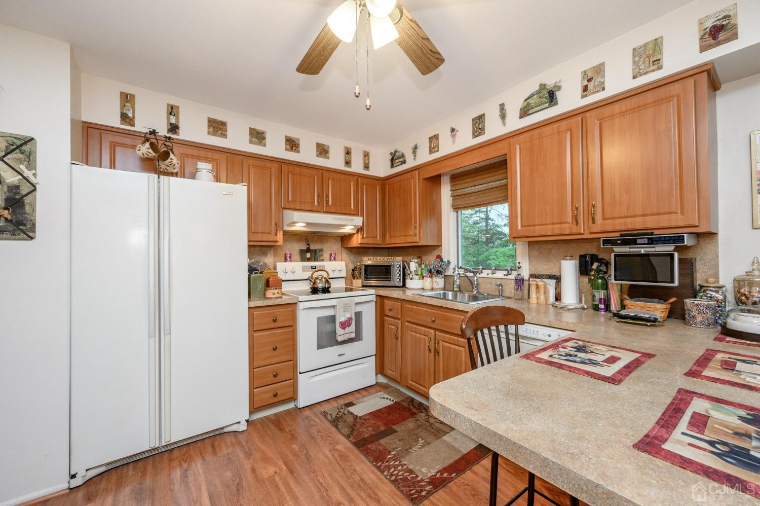 25 Sunset Drive Andover, NJ 07821 - Photo 13 of 43 a kitchen with stainless steel appliances granite countertop a refrigerator a stove top oven a sink dishwasher and white cabinets with wooden floor