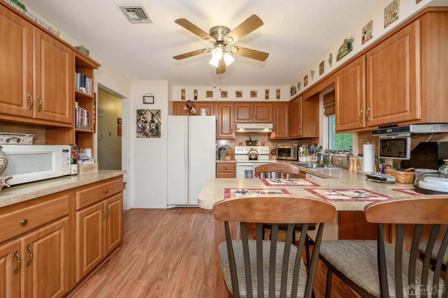 25 Sunset Drive Andover, NJ 07821 - Photo 10 of 43 a kitchen with stainless steel appliances granite countertop a refrigerator a stove top oven a sink dishwasher and white cabinets with wooden floor