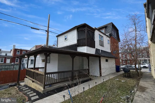a view of a house with a small yard and wooden fence