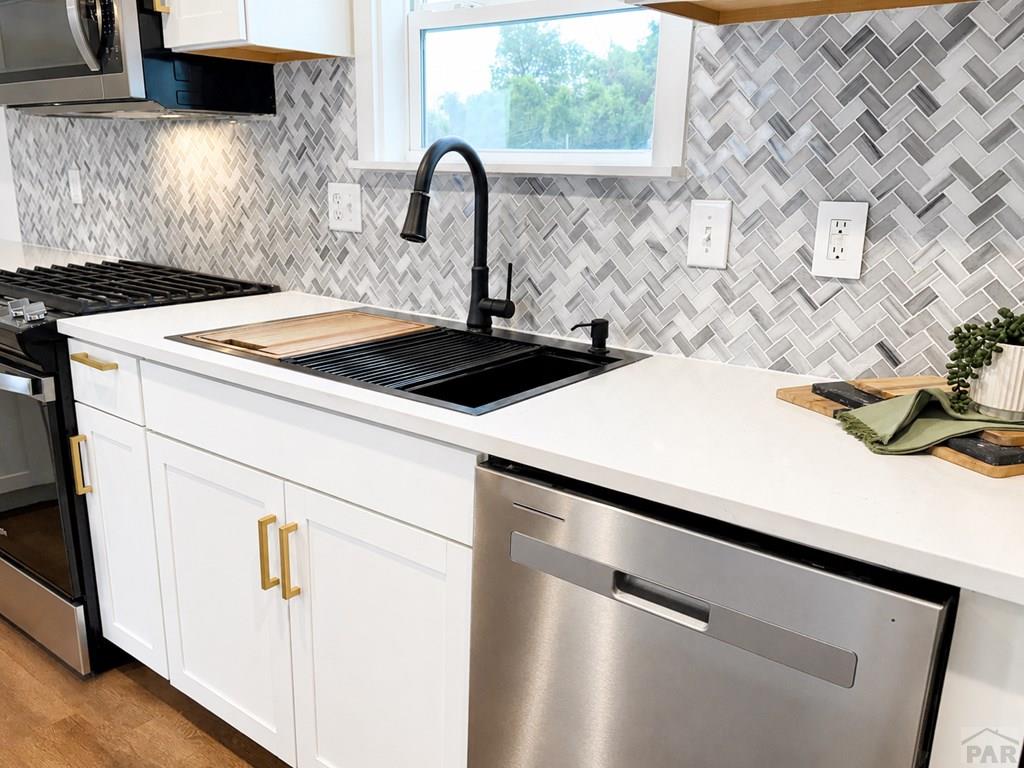 6652 County Rd HH.5 Lamar, CO 81052 - Photo 3 of 22 a close view of a stove a sink and dishwasher with wooden floor