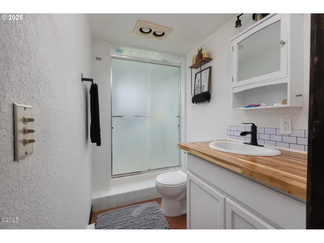 a bathroom with a granite countertop sink toilet and shower