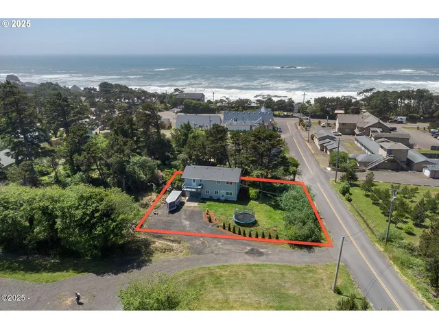 an aerial view of residential houses with outdoor space and ocean view