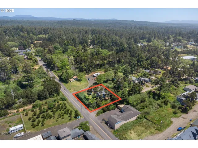 an aerial view of a residential houses with outdoor space and trees