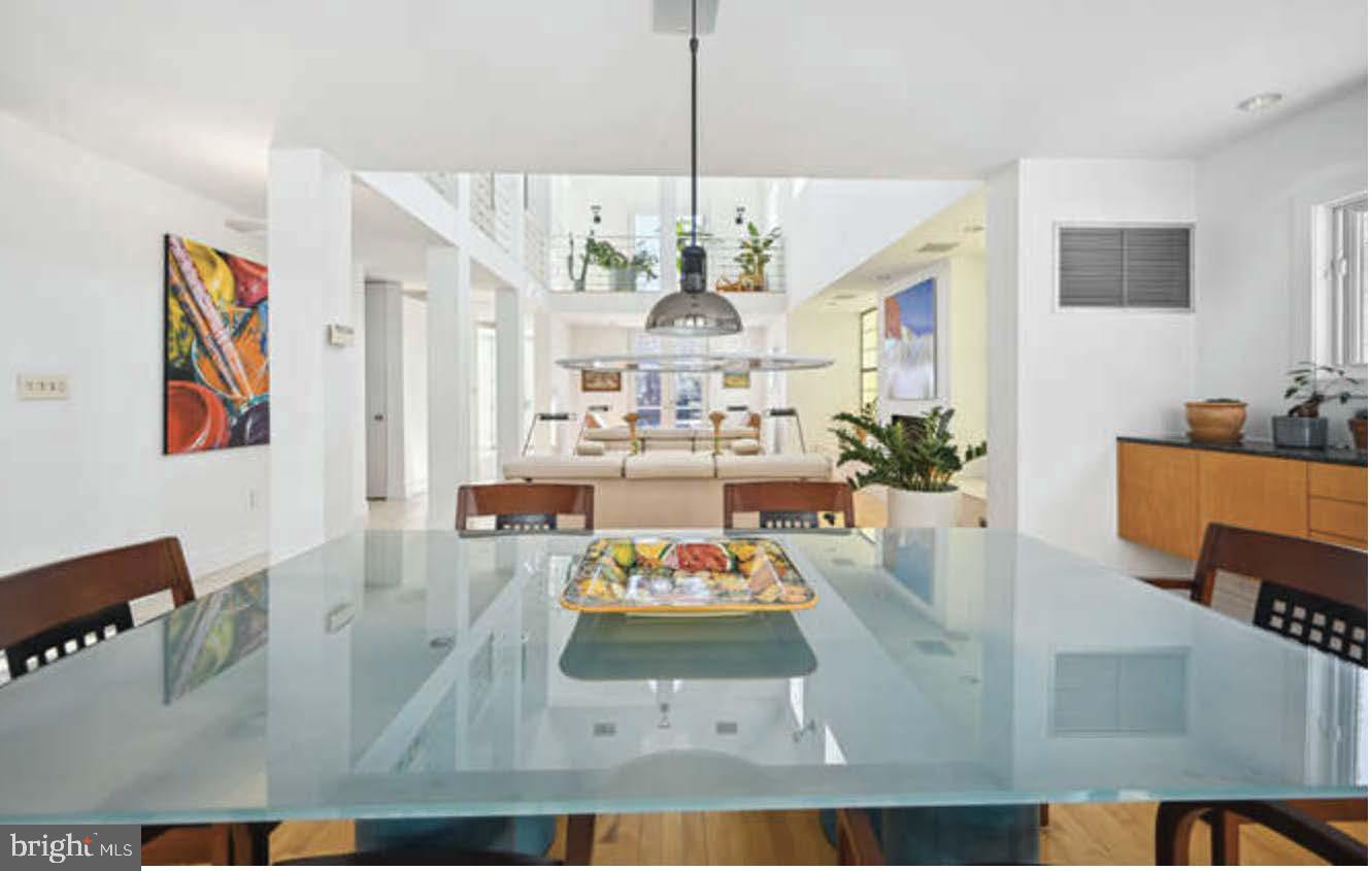 4527 Q Place Northwest Washington, DC 20007 - Photo 42 of 54 a view of dining room and livingroom with furniture wooden floor a rug a painting and a chandelier