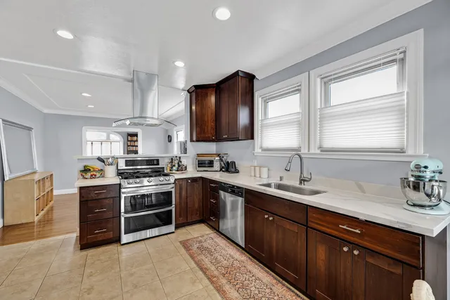 a kitchen with stainless steel appliances granite countertop a sink dishwasher stove and refrigerator