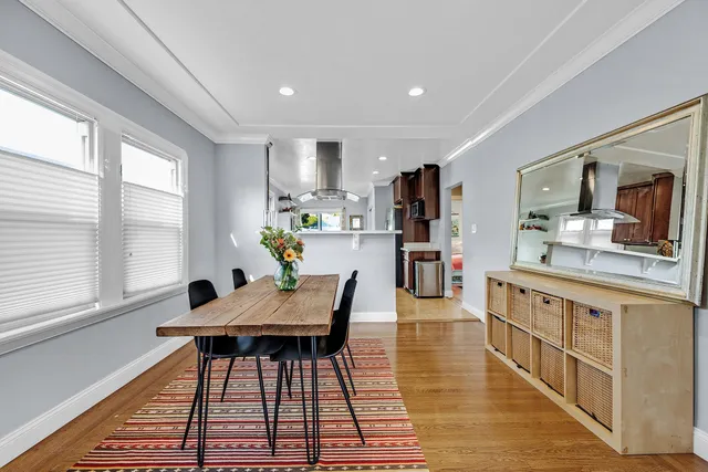 a kitchen with stainless steel appliances kitchen island granite countertop a table chairs in it and a window