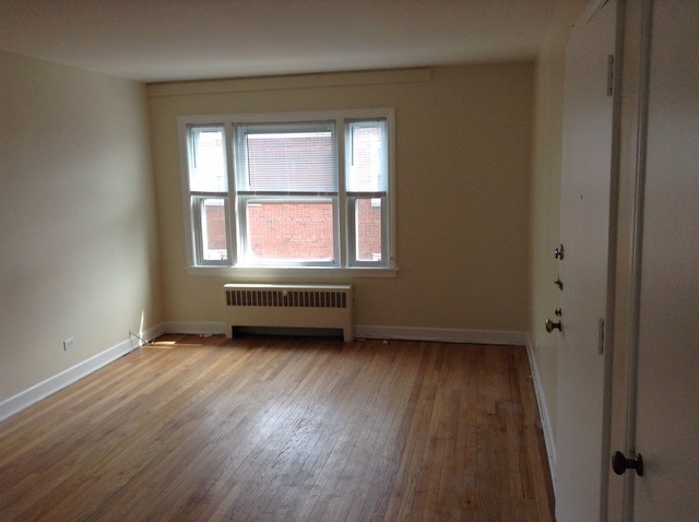 7522 North Ridge Boulevard, Unit 3E Chicago, IL 60645 - Photo 2 of 7 an empty room with wooden floor and windows