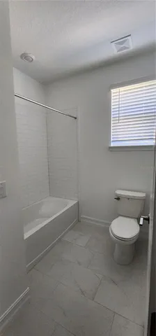 a view of an empty room with a fireplace and a window