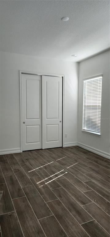 29868 Picana Lane Wesley Chapel, FL 33543 - Photo 50 of 75 a view of an empty room with wooden floor and a window
