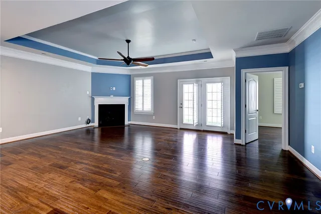 a view of a livingroom with wooden floor and a ceiling fan