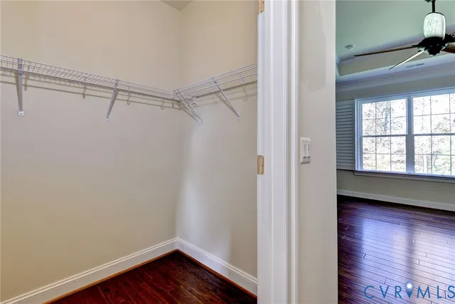 a view of walk in closet with wooden floor and windows