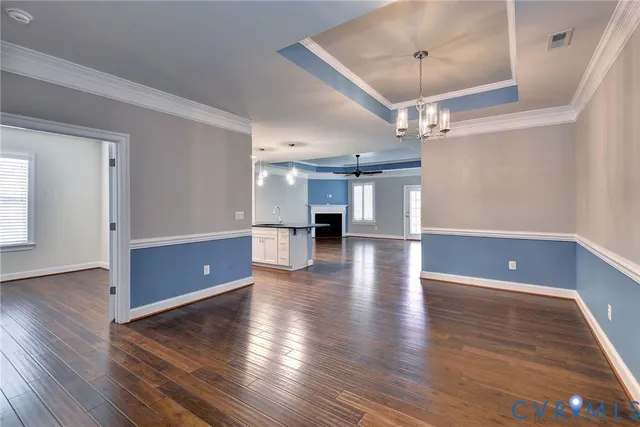 a view of a room with wooden floor staircase and a kitchen