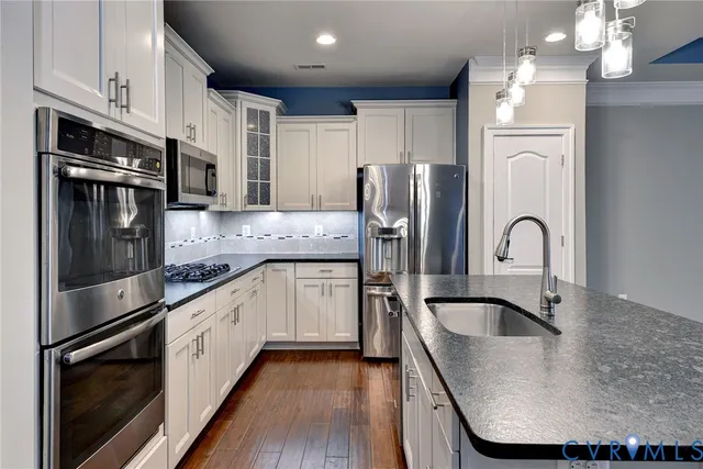 a kitchen with stainless steel appliances granite countertop a sink stove and refrigerator