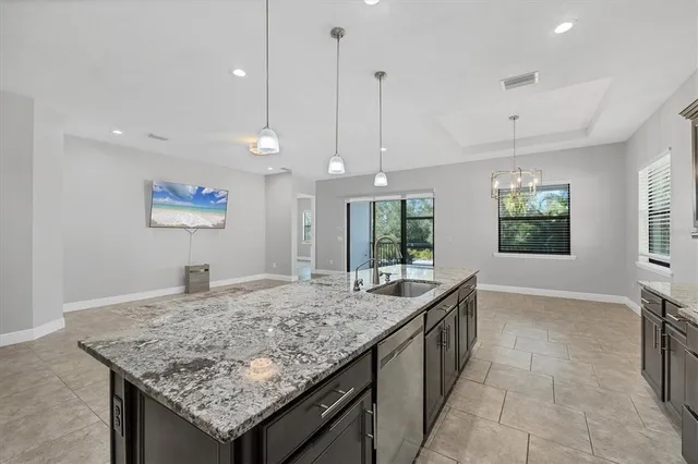 a kitchen with stainless steel appliances granite countertop a kitchen island a stove and a sink