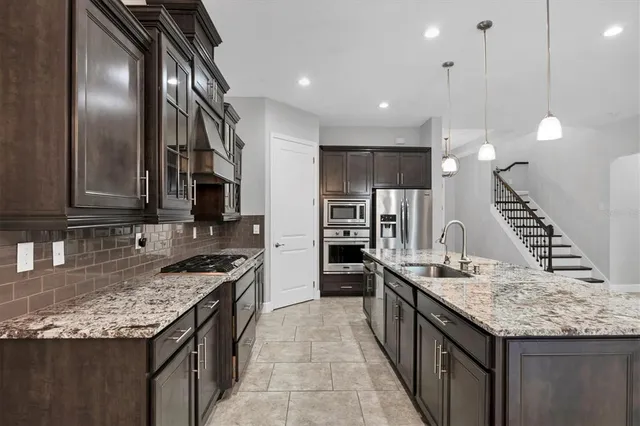 a view of a kitchen with a sink and a refrigerator