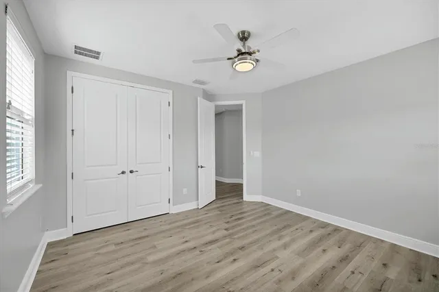 a view of a big room with wooden floor and windows