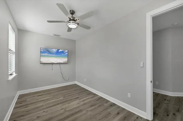 an empty room with a window and a fan