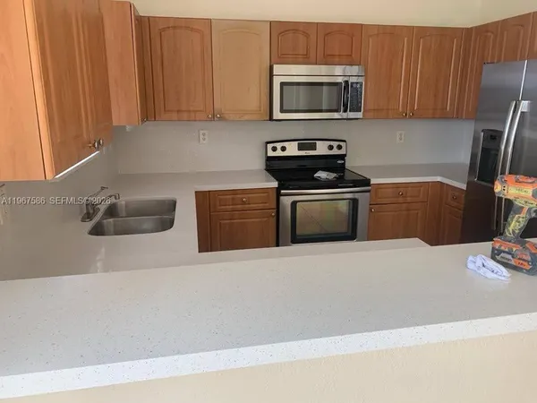 a stove top oven sitting inside of a kitchen and granite counter tops