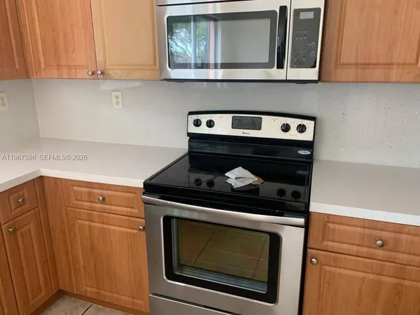 a kitchen with granite countertop a sink and a stove top oven with wooden floor