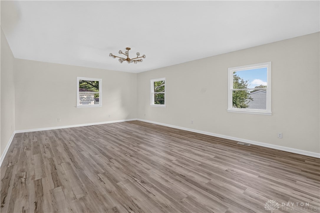 1243 Student Avenue Springfield, OH 45503 - Photo 9 of 38 Polished wood-style flooring and multipane windows define this versatile, airy interior space.