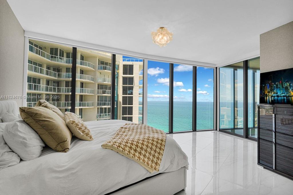 18555 Collins Avenue, Unit 2605 Sunny Isles Beach, FL 33160 - Photo 14 of 22 a bedroom with a bed and a large window