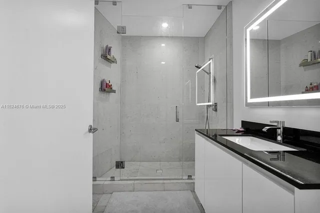 a bathroom with a granite countertop sink a shower and a mirror