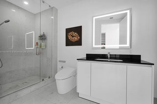a bathroom with a granite countertop sink a toilet and shower