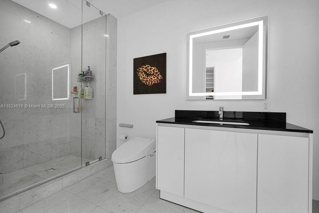 18555 Collins Avenue, Unit 2605 Sunny Isles Beach, FL 33160 - Photo 18 of 22 a bathroom with a granite countertop sink a toilet and shower