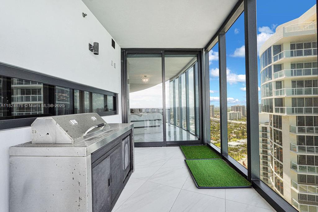 18555 Collins Avenue, Unit 2605 Sunny Isles Beach, FL 33160 - Photo 19 of 22 a living room with a bed and a large window