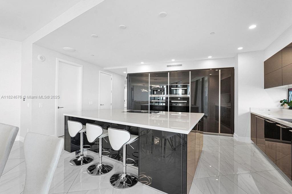 18555 Collins Avenue, Unit 2605 Sunny Isles Beach, FL 33160 - Photo 7 of 22 a room with table and chairs