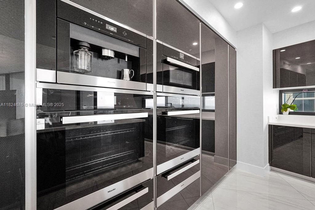 18555 Collins Avenue, Unit 2605 Sunny Isles Beach, FL 33160 - Photo 10 of 22 a kitchen with stainless steel appliances and cabinets