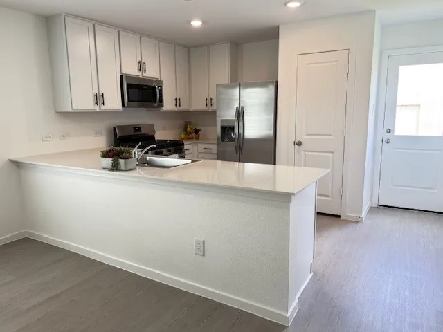 a kitchen with a refrigerator a stove a microwave and cabinets