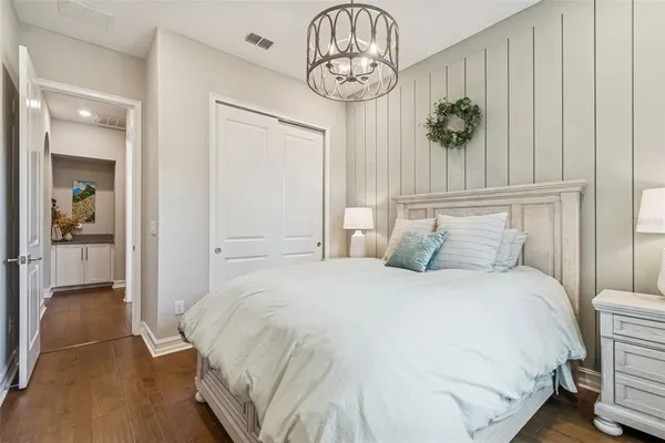 a spacious bedroom with a large bed and a chandelier