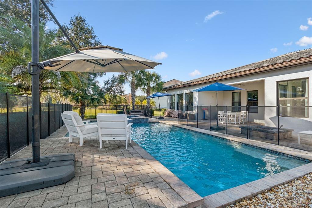 2519 Cordoba Ranch Boulevard Lutz, FL 33559 - Photo 48 of 77 a view of a patio with couches table and chairs under an umbrella
