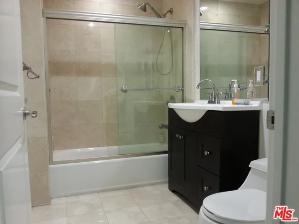 a bathroom with a sink vanity mirror and toilet