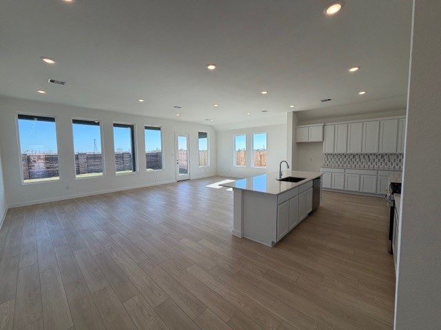 8207 Holly Blue Drive Rosharon, TX 77583 - Photo 5 of 28 a large kitchen with stainless steel appliances granite countertop a large counter top a wooden floors and a large window