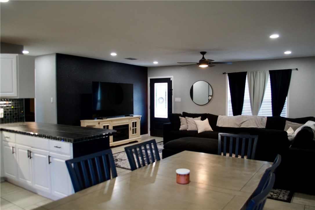 1001 East Hefferman Street Beeville, TX 78102 - Photo 8 of 12 a living room with furniture a flat screen tv and kitchen view